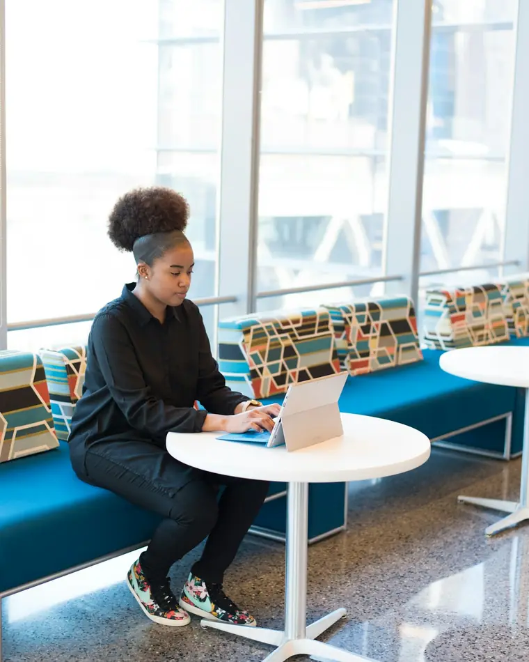 A learner practising at a study table by a window.